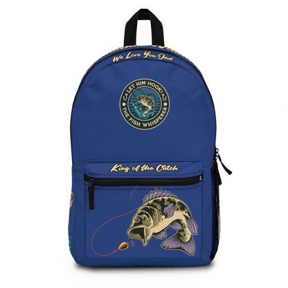 a blue backpack that has graphic of bass fish and fishing reel, with words let him hook the fish whisperer, king of the catch, we o'fishally love you dad, with last name of a person on the top